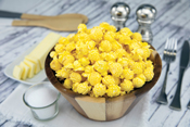 Poppin Popcorn Movie Theater Butter popcorn in a bowl with ingredients all around it on a table.
